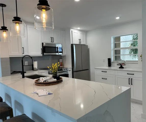 a kitchen with refrigerator and stove