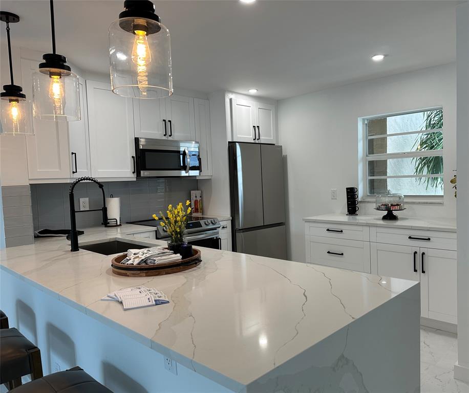 2300 Northeast 1st Lane, Unit 201 Boynton Beach, FL 33435 - Photo 2 of 34 a kitchen with refrigerator and stove