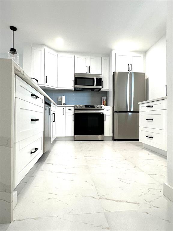 2300 Northeast 1st Lane, Unit 201 Boynton Beach, FL 33435 - Photo 3 of 34 a kitchen with granite countertop a refrigerator and a stove top oven