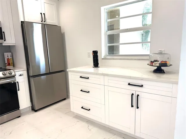 a kitchen with a refrigerator and window