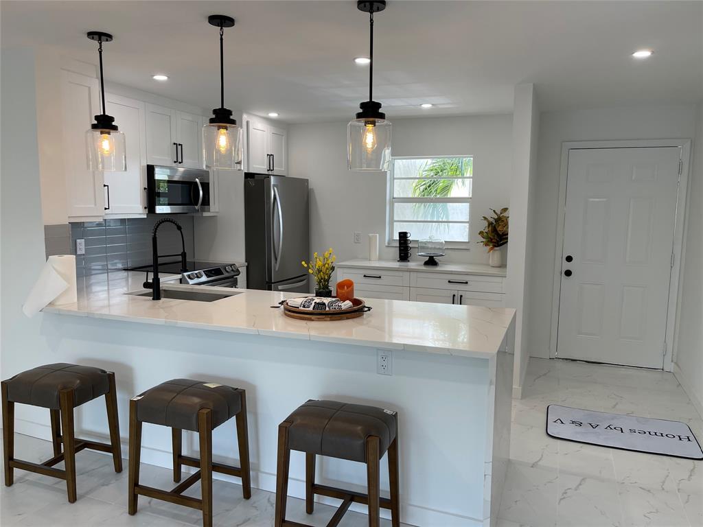 2300 Northeast 1st Lane, Unit 201 Boynton Beach, FL 33435 - Photo 5 of 34 a kitchen with a sink cabinets and window