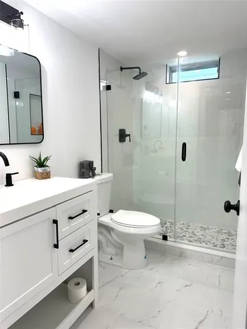 a bathroom with a toilet sink and shower
