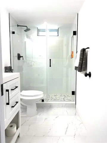 a bathroom with a toilet sink and shower