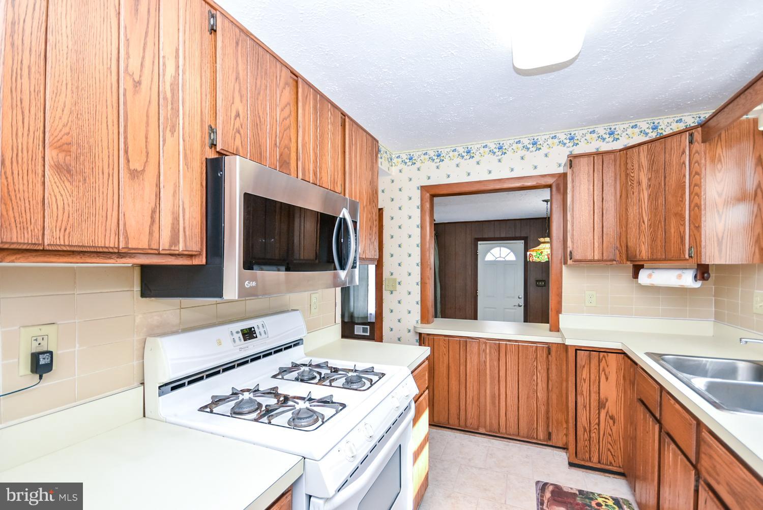 12311 Judson Road Silver Spring, MD 20906 - Photo 6 of 29 a kitchen with stainless steel appliances a stove a sink and a microwave