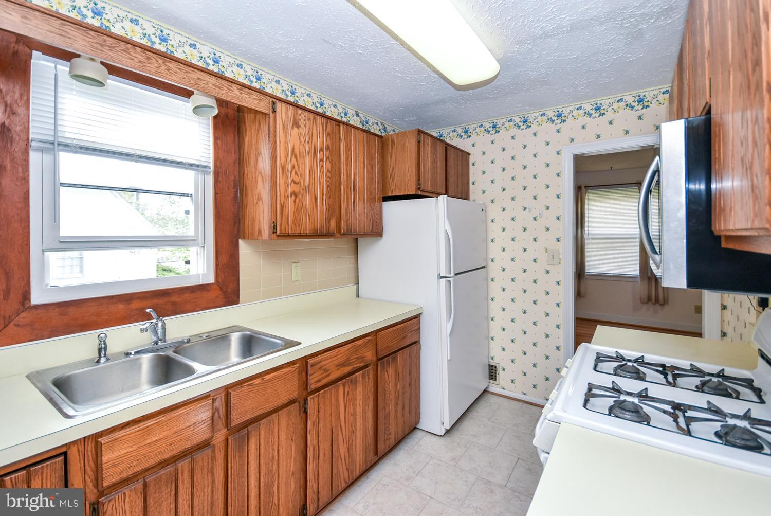 12311 Judson Road Silver Spring, MD 20906 - Photo 7 of 29 a kitchen with stainless steel appliances granite countertop a sink stove and refrigerator