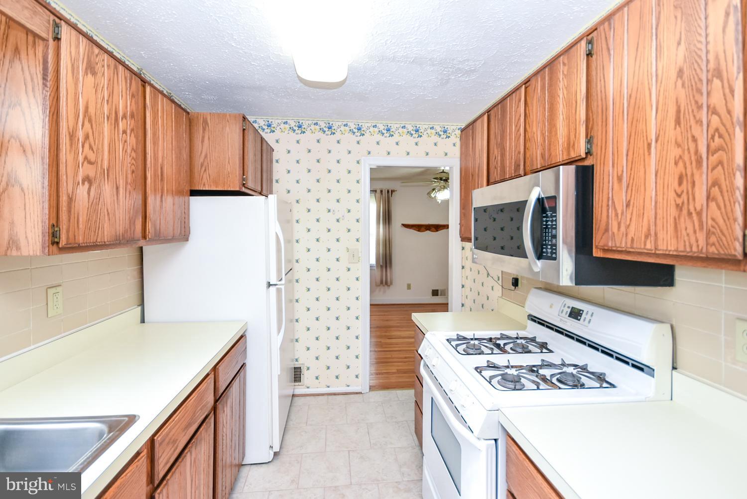 12311 Judson Road Silver Spring, MD 20906 - Photo 8 of 29 a kitchen with a stove a sink and a microwave