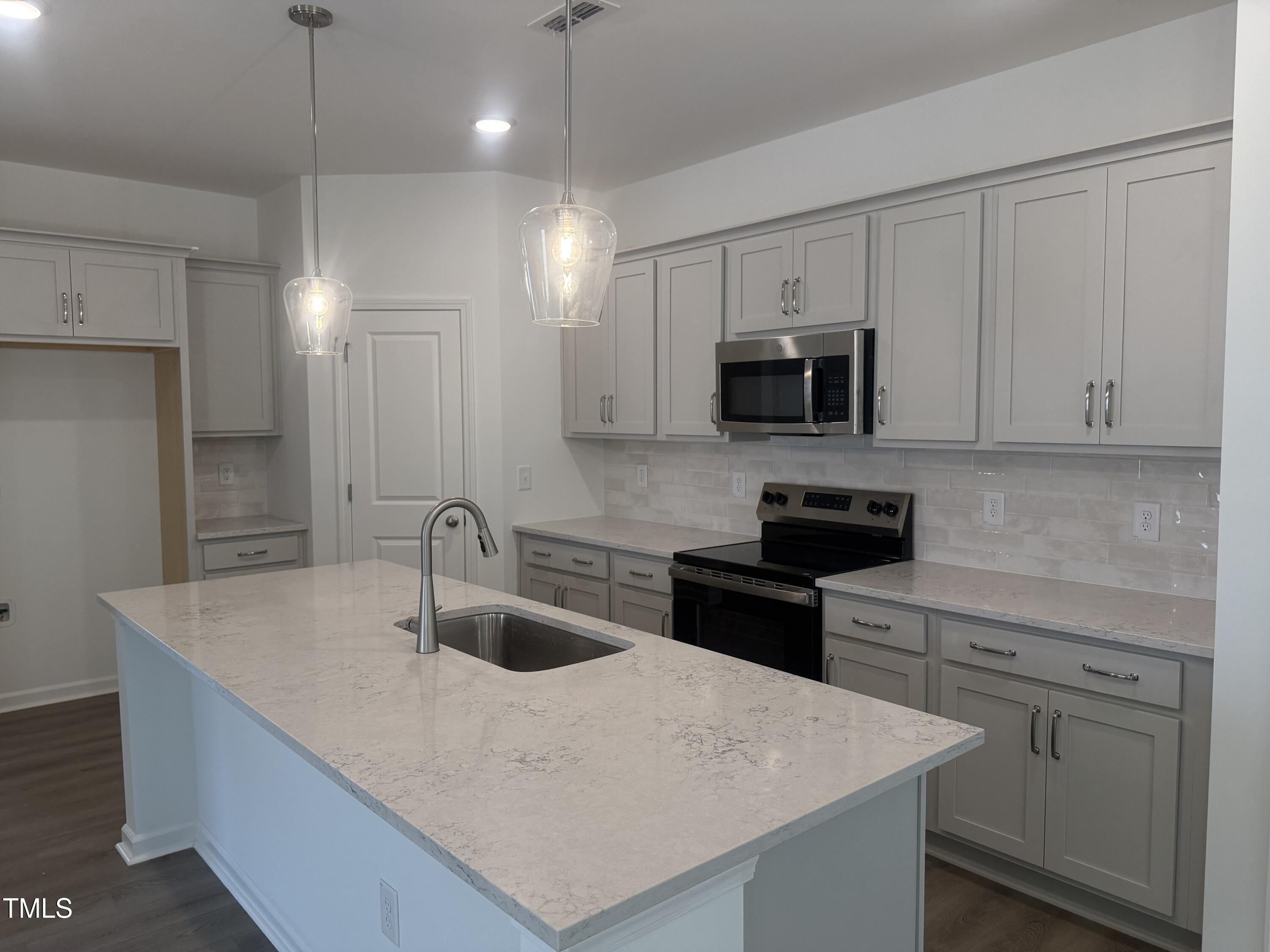 11185 Salers Loop Middlesex, NC 27557 - Photo 4 of 41 a kitchen with kitchen island a sink and stainless steel appliances