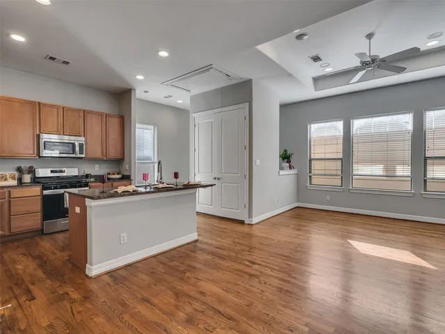 a kitchen with wooden floors and appliances