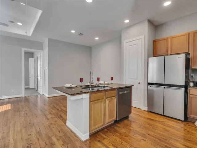 a kitchen with a sink a refrigerator and white cabinets
