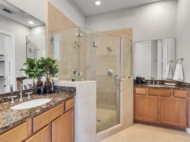 a bathroom with a granite countertop sink a mirror and shower