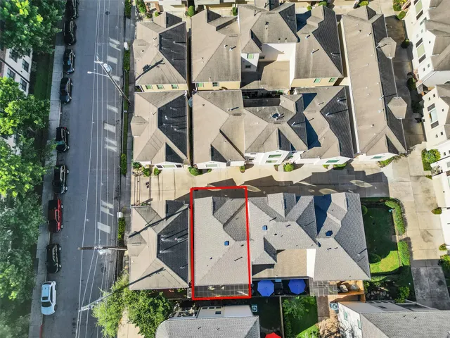an aerial view of residential houses with outdoor space and parking