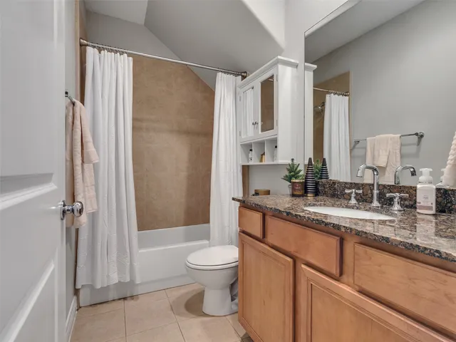 a bathroom with a granite countertop sink mirror vanity and toilet