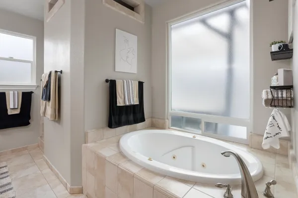 a bathroom with a tub sink and mirror