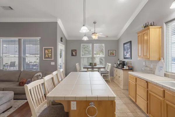 a large kitchen with kitchen island a stove a sink a dining table and chairs