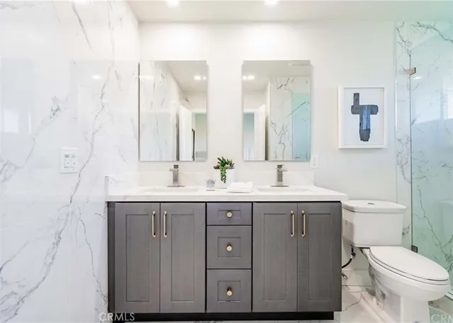 a bathroom with a granite countertop sink a toilet and a mirror