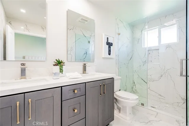 a bathroom with a granite countertop sink a toilet and a mirror
