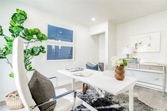 a view of a dining room with furniture a potted plant and wooden floor