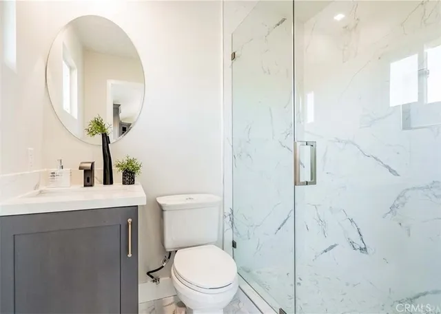 a bathroom with a toilet a sink and mirror