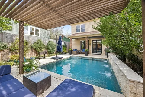 a view of a backyard with a large pool and couches chairs