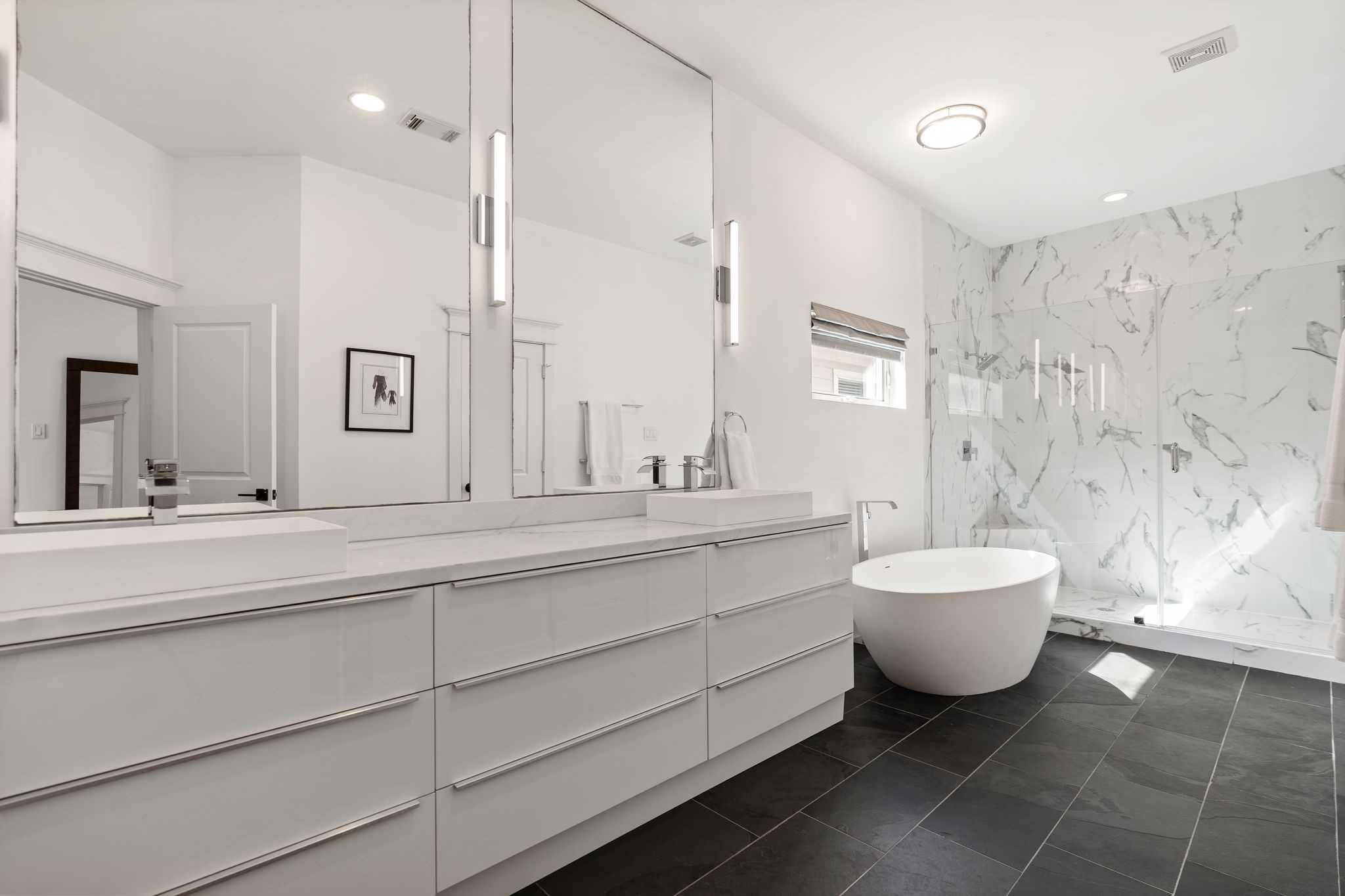 925 Waverly Street, Unit B Houston, TX 77008 - Photo 26 of 36 Fully renovated in 2017, the palatial en suite primary bathroom impresses with an oversized walk-in rain shower for two, a freestanding soaking tub and a wide double vanity all surrounded by floor-to-ceiling tile.