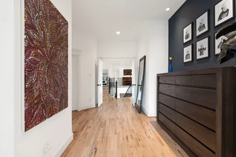 a view of a hallway with wooden floor and staircase