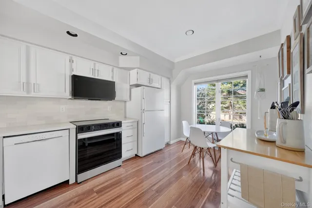 a kitchen with cabinets stainless steel appliances a sink and a window