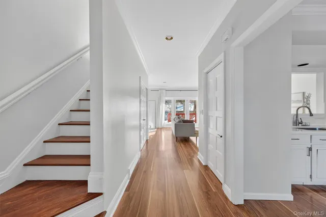 a view of a hallway with wooden floor and staircase