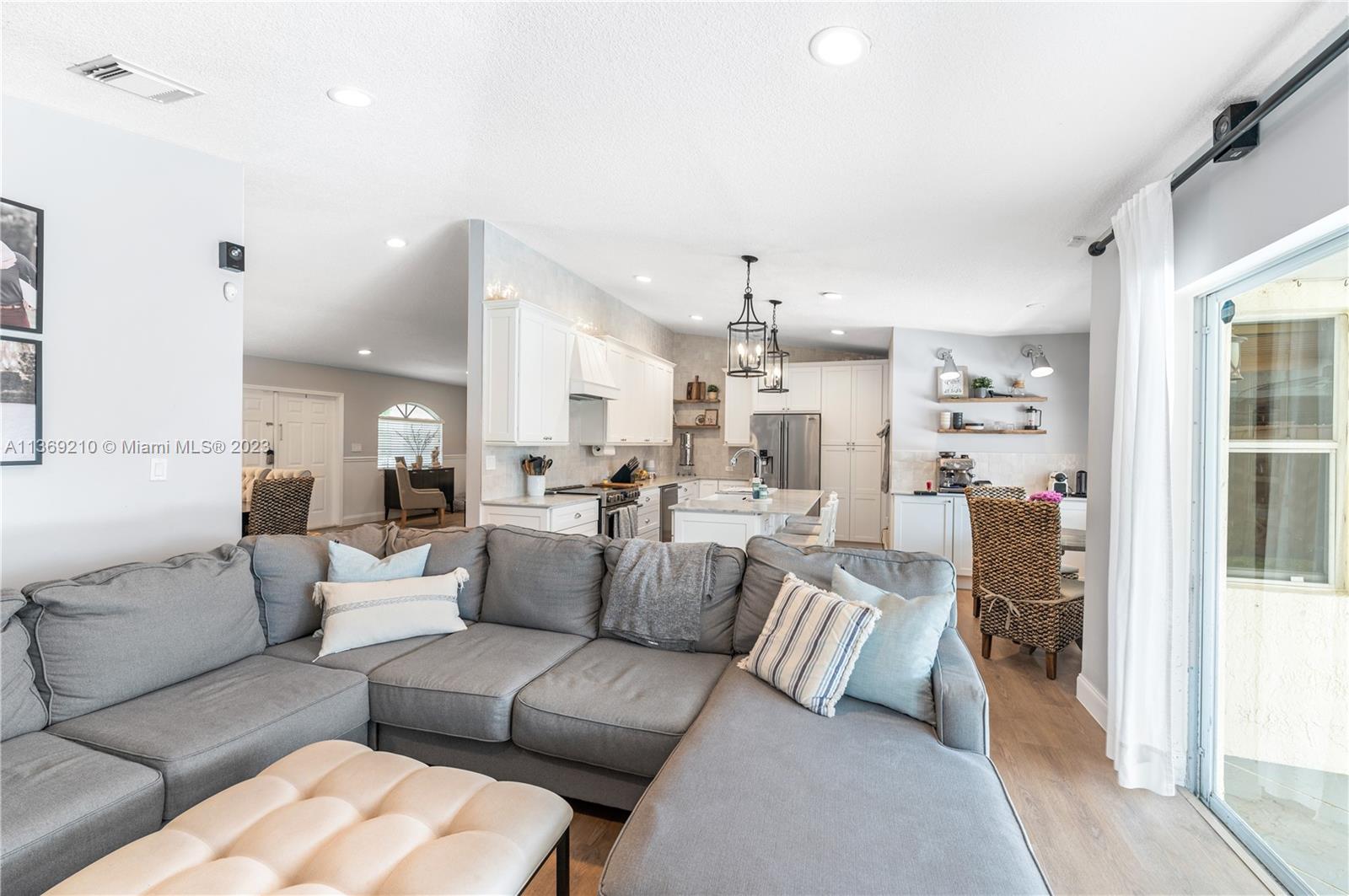 18217 Southwest 148th Ave Road Miami, FL 33187 - Photo 15 of 29 a living room with furniture white walls and a chandelier