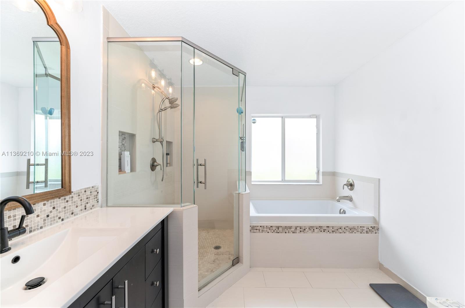 18217 Southwest 148th Ave Road Miami, FL 33187 - Photo 18 of 29 a bathroom with a tub a sink and a mirror