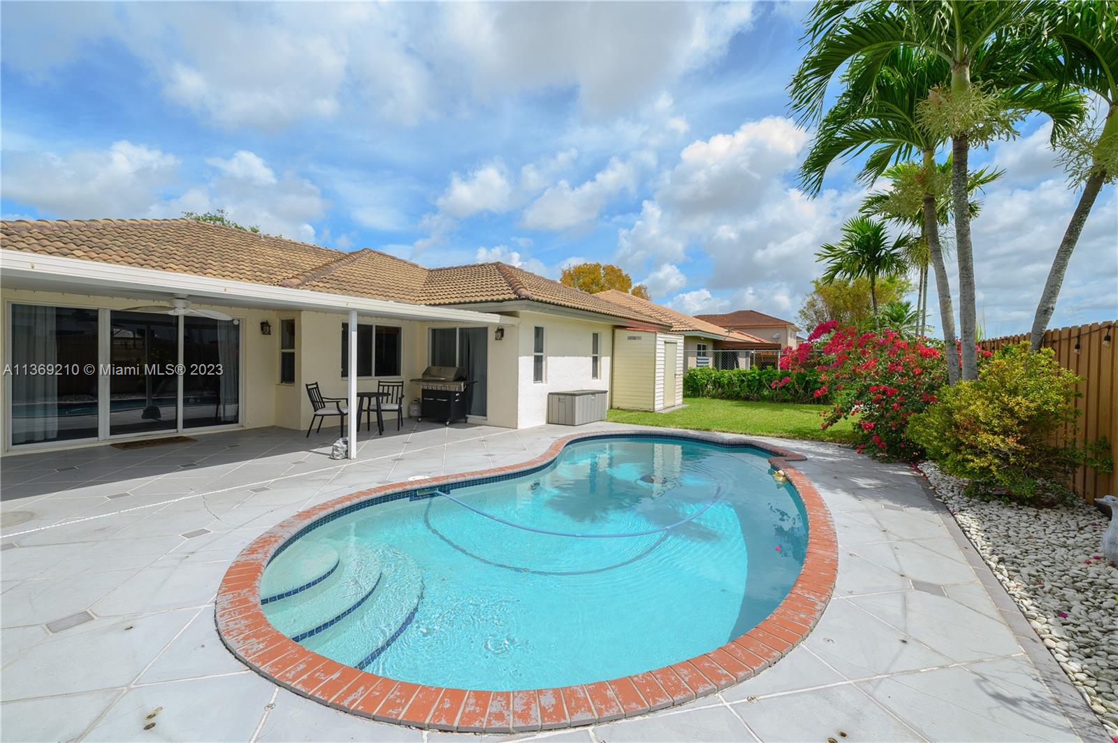 18217 Southwest 148th Ave Road Miami, FL 33187 - Photo 26 of 29 a view of a house with swimming pool and porch