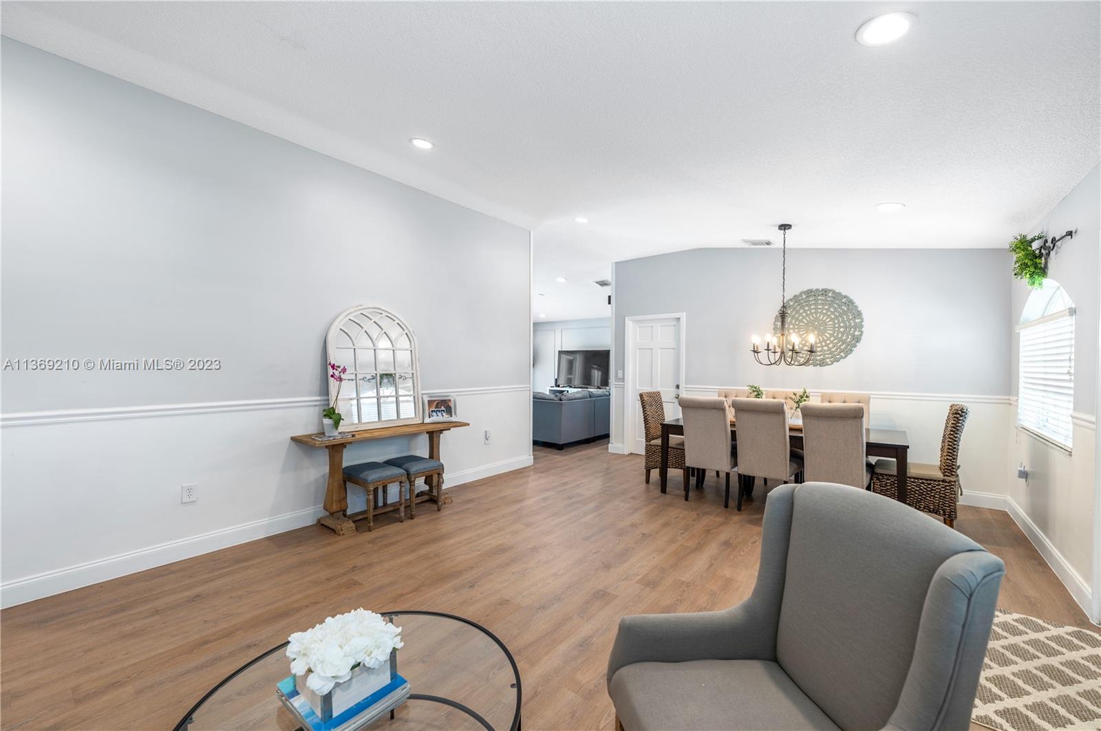 18217 Southwest 148th Ave Road Miami, FL 33187 - Photo 5 of 29 a living room with furniture a chandelier and a table