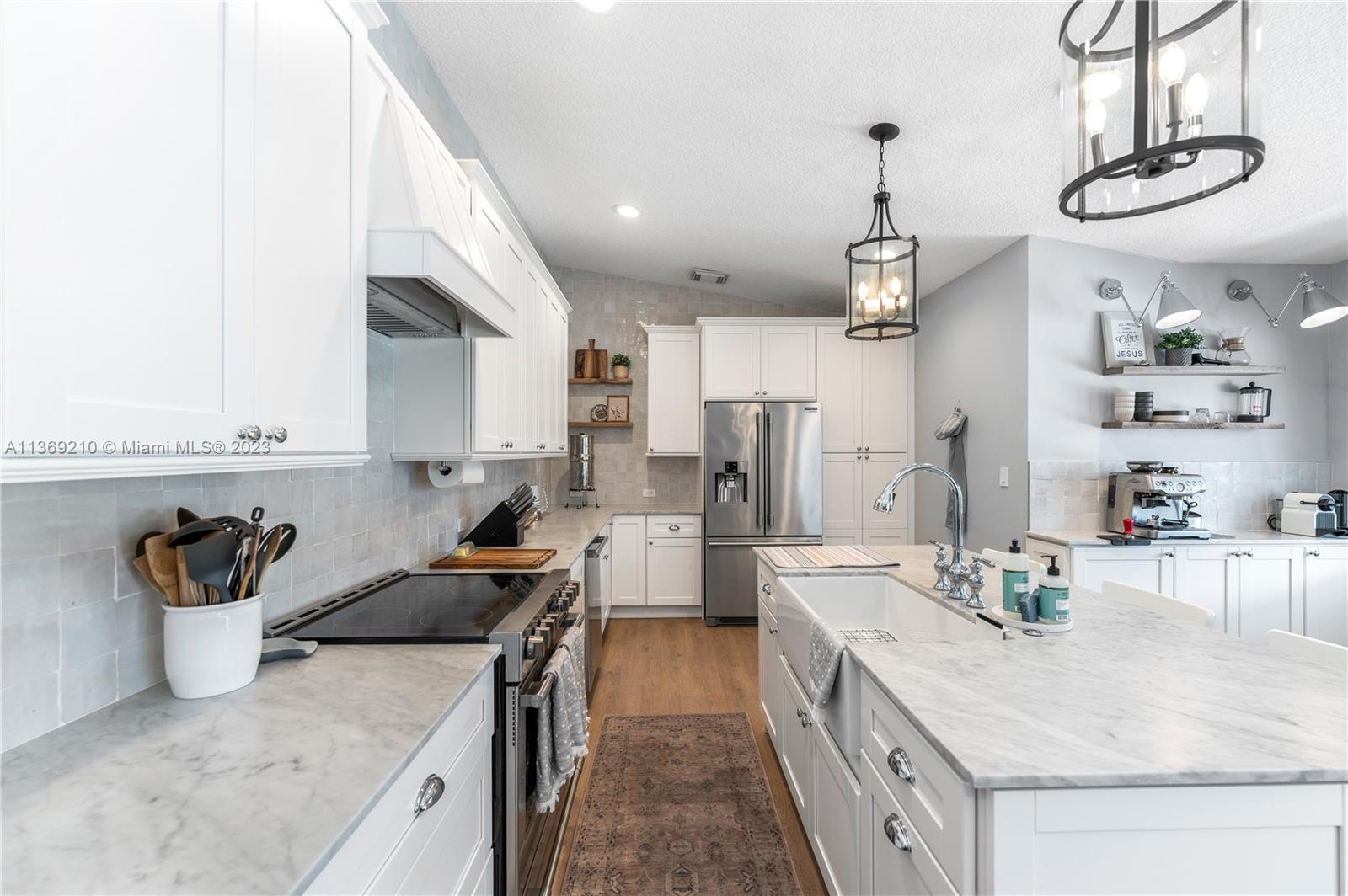 18217 Southwest 148th Ave Road Miami, FL 33187 - Photo 8 of 29 a kitchen with stainless steel appliances granite countertop a sink stove and refrigerator