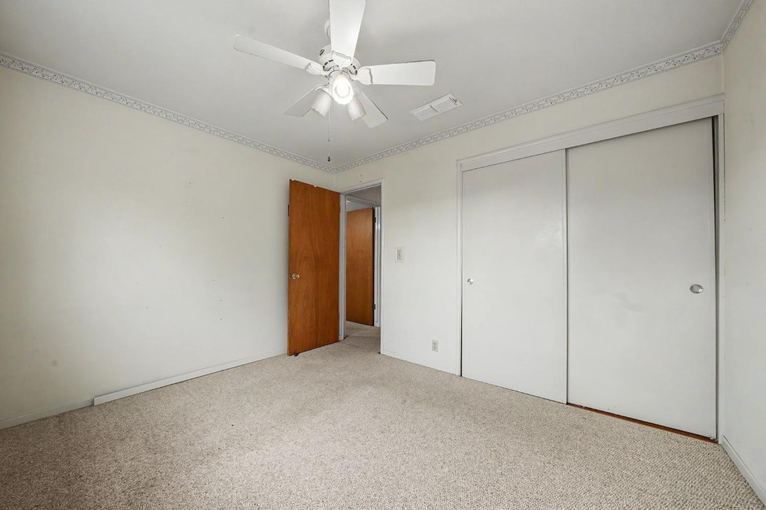 626 Sutter Lane Ione, CA 95640 - Photo 16 of 21 an empty room with a ceiling fan and carpet