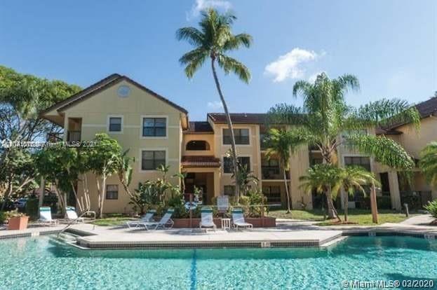 4581 West McNab Road, Unit 14 Pompano Beach, FL 33069 - Photo 1 of 10 a view of a house with a yard and palm trees
