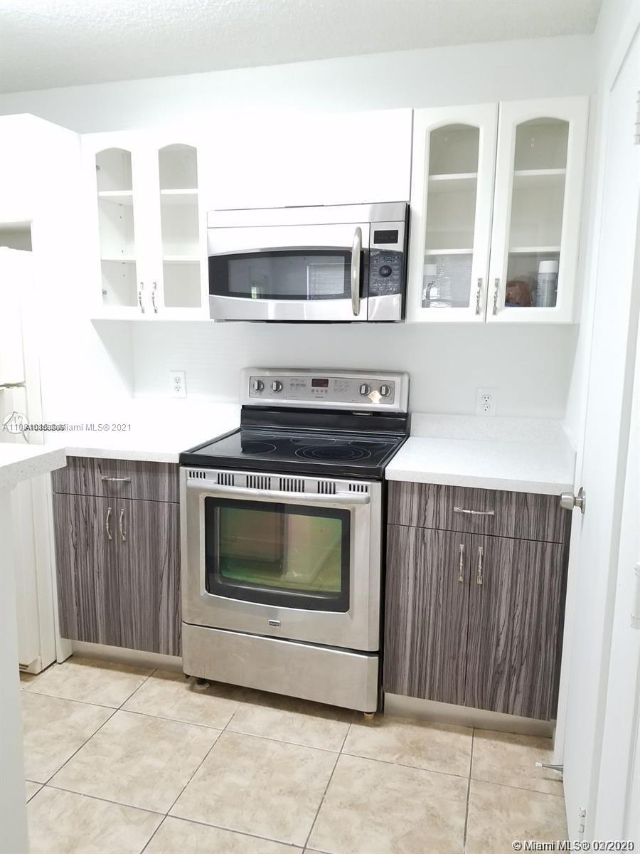 4581 West McNab Road, Unit 14 Pompano Beach, FL 33069 - Photo 2 of 10 a kitchen with stainless steel appliances a stove and a microwave