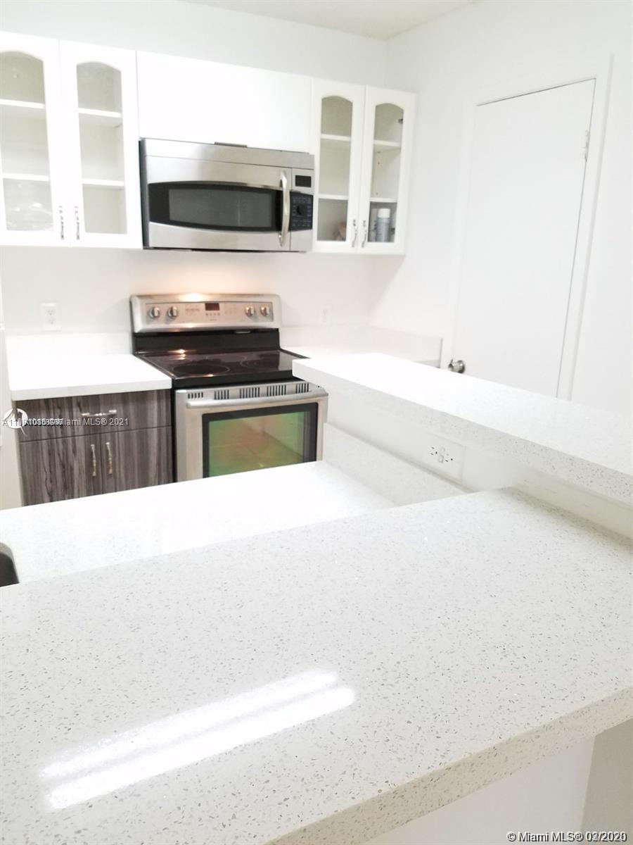 4581 West McNab Road, Unit 14 Pompano Beach, FL 33069 - Photo 5 of 10 a kitchen with stainless steel appliances a stove microwave and sink