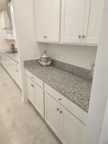 a kitchen with granite countertop white cabinets and a white stove top oven