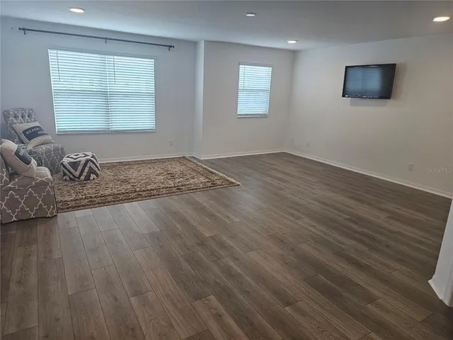 a view of a livingroom with wooden floor and a window