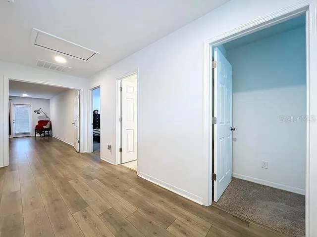 a view of a livingroom with wooden floor & a ceiling fan