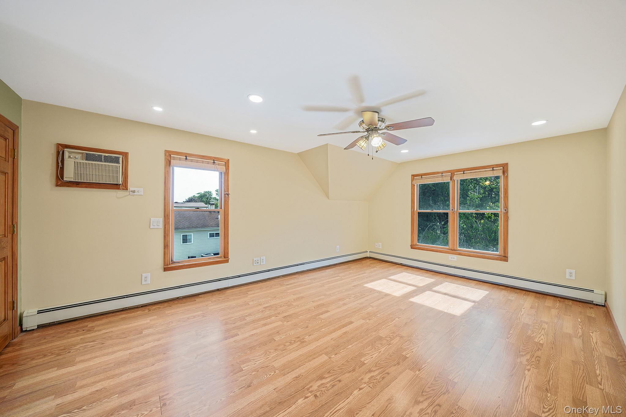 26 Bokel Road Ronkonkoma, NY 11779 - Photo 13 of 34 a view of an empty room with a window and wooden floor