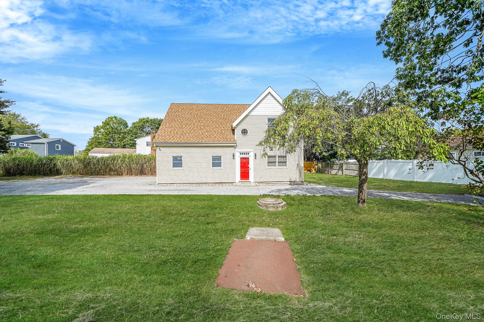 26 Bokel Road Ronkonkoma, NY 11779 - Photo 31 of 34 a white house with a yard and plants