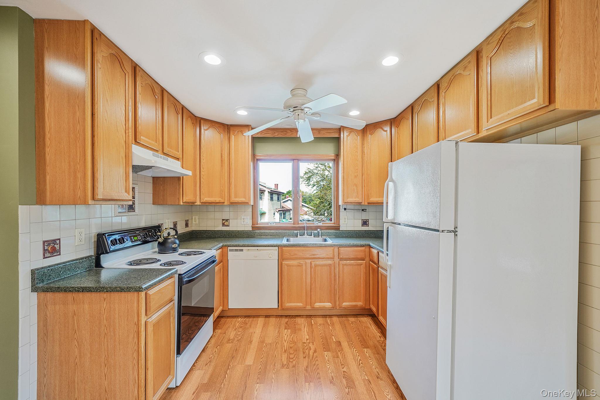 26 Bokel Road Ronkonkoma, NY 11779 - Photo 4 of 34 a kitchen with stainless steel appliances granite countertop a refrigerator a sink dishwasher a stove with large countertops and wooden floor