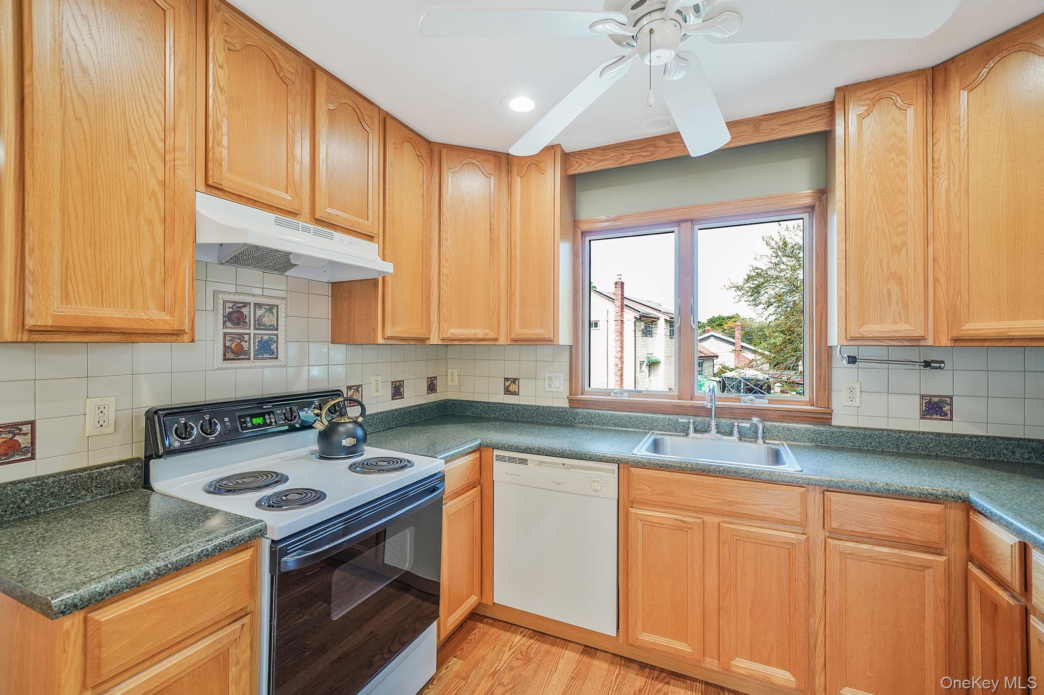 26 Bokel Road Ronkonkoma, NY 11779 - Photo 5 of 34 a kitchen with granite countertop a sink a counter space appliances and cabinets