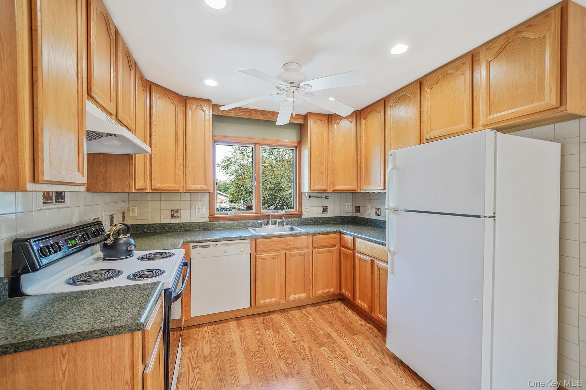26 Bokel Road Ronkonkoma, NY 11779 - Photo 6 of 34 a kitchen with stainless steel appliances granite countertop a refrigerator a sink dishwasher a stove with wooden cabinets and floor