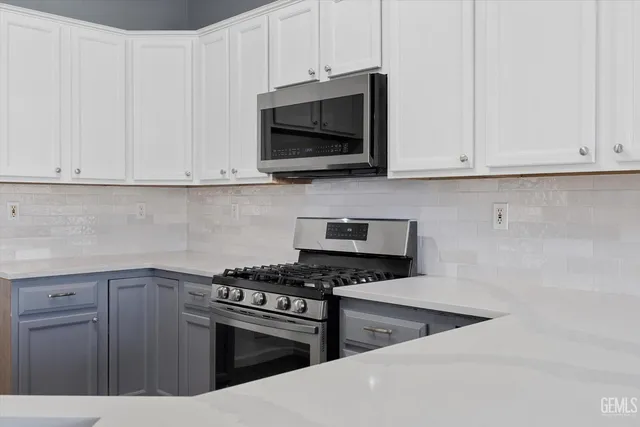 a kitchen with stainless steel appliances granite countertop a stove a sink dishwasher and a microwave oven with wooden floor