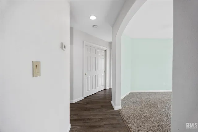 an empty room with windows and ceiling fan