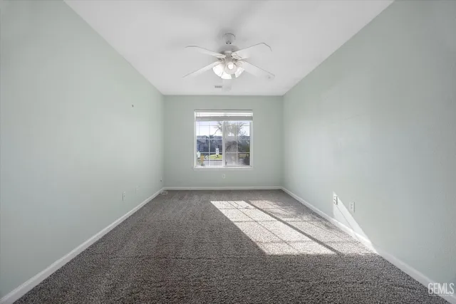 a bedroom with a bed and a chandelier fan