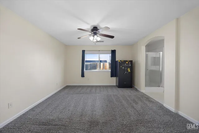a view of empty room with wooden floor and ceiling fan