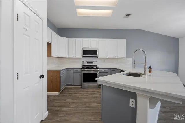 a kitchen with stainless steel appliances granite countertop a stove a microwave and cabinets