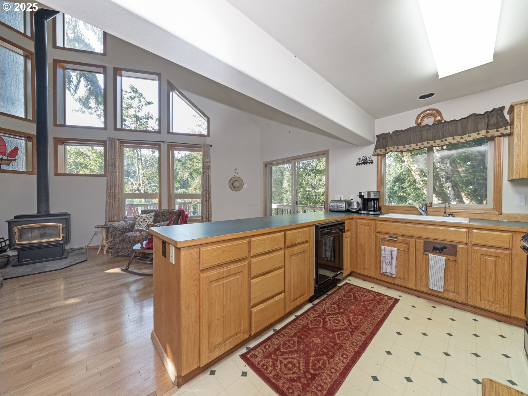 71397 Fishhawk Road Clatskanie, OR 97016 - Photo 14 of 48 a large kitchen with stainless steel appliances a stove a sink a dining table and chair with wooden floor